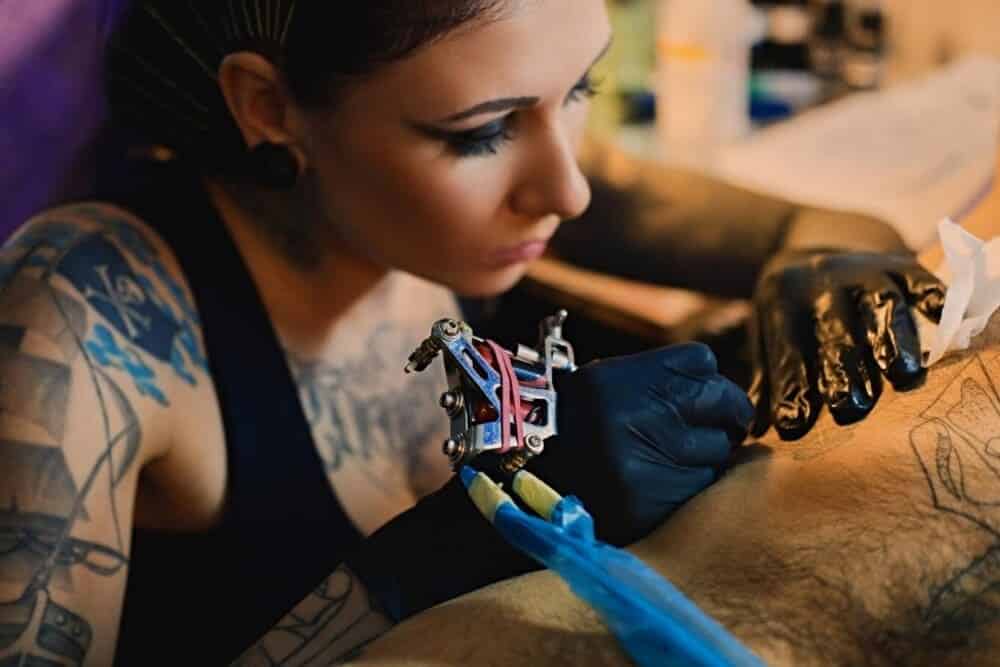 tatuadora realizando cover up cliente