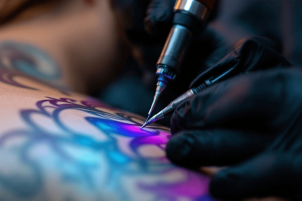 detalle de maquina de tatuar aplicando tinta colorida en brazo de persona durante sesion en estudio moderno de tatuajes